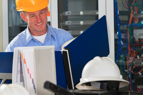 Electrical engineer reviewing data logs in broadband communication hub
