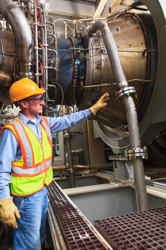 Engineer at fuel ignition stage of gas turbine which drives generators in power plant while turbine