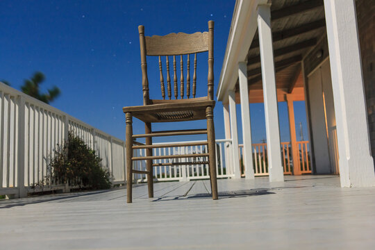 Antique chair on deck of vacation home at midnight