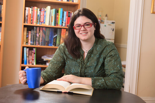 Woman with Asperger syndrome relaxing with a mug of tea and a book