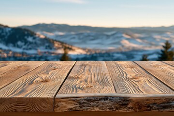 Naklejka premium Rustic wooden table surface with a soft focus background of snow-covered mountains at sunset.
