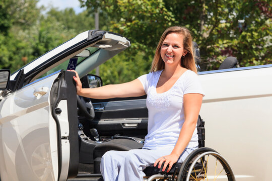 Woman with a spinal cord injury in her wheelchair and getting into her adaptive vehicle