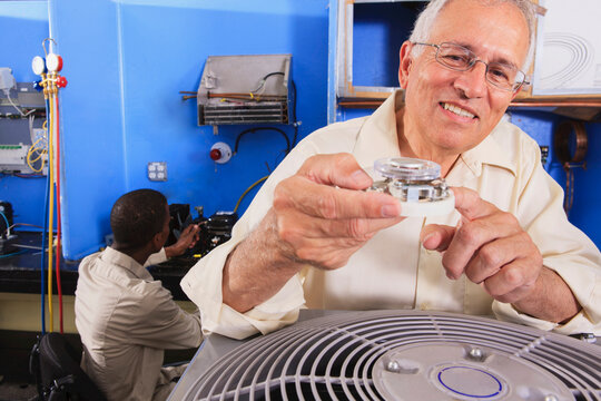 Instructor training students on basic thermostat operation in HVAC classroom
