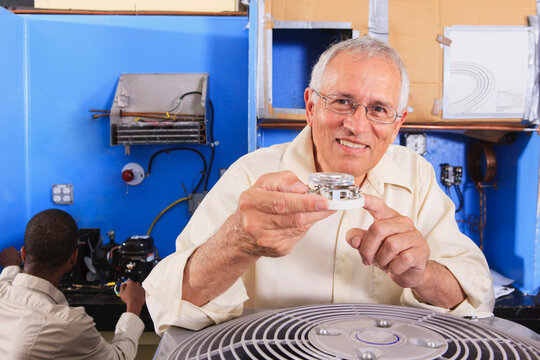 Instructor training students on basic thermostat operation in HVAC classroom