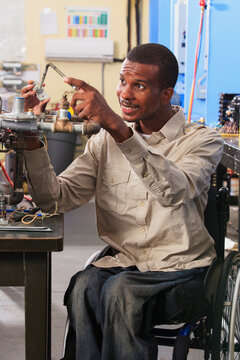 Student in wheelchair examining furnace ignitor in HVAC classroom