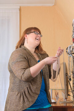 Woman who is legally blind picking out jewelry to dress up in her home