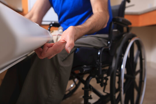 Man with Friedreich's Ataxia and deformed hands using his dishwasher