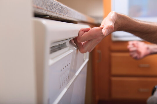 Man with Friedreich's Ataxia and deformed hands using his dishwasher
