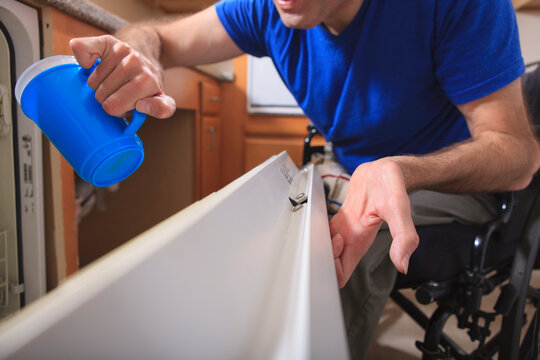 Man with Friedreich's Ataxia and deformed hands using his dishwasher