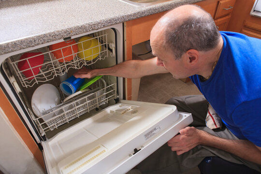 Man with Friedreich's Ataxia and deformed hands using his dishwasher
