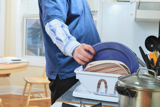 Man with Asperger's living in his home and washing dishes