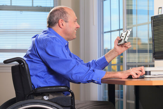 Man with Friedreich's Ataxia and deformed hands as an electronic design engineer at his workstation