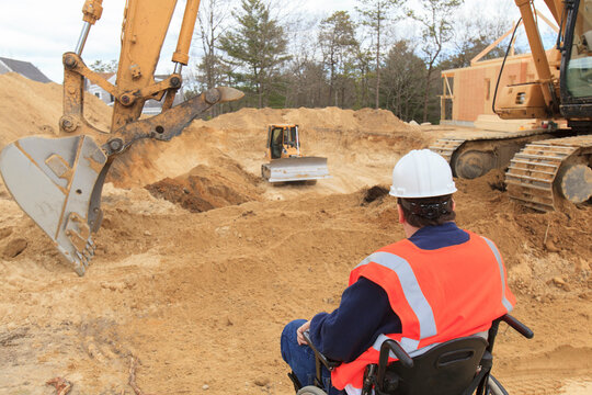 Construction engineer with spinal cord injury inspecting new foundation hole
