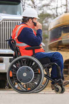 Construction engineer with spinal cord injury talking on radio at home construction site