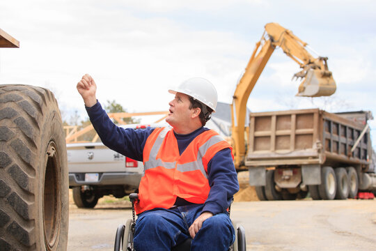 Construction engineer with spinal cord injury talking with front end loader operator