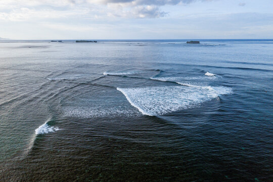 Aerial view of waves breaking in a cross sea pattern over a coral reef near Siargao Island General Luna, Caraga, Philippines.