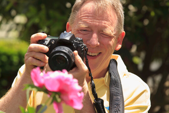 Man with Cerebral Palsy and dyslexia photographing his flowers