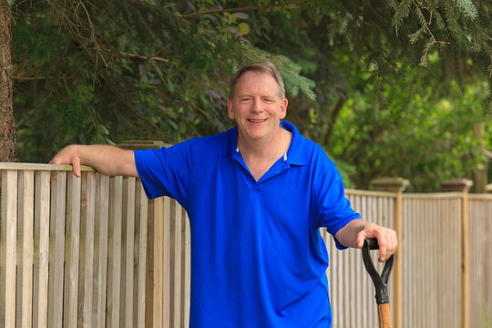 Man with Cerebral Palsy and dyslexia relaxing at his garden fence