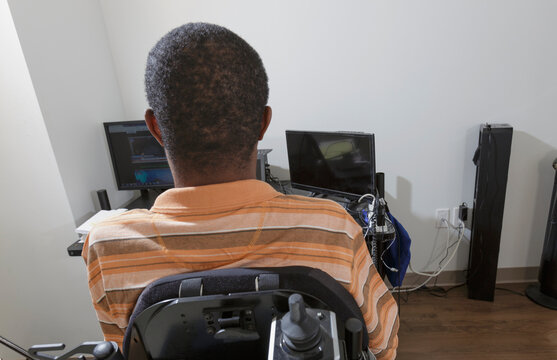 Man with Guillain-Barre Syndrome using his technical equipment at home office