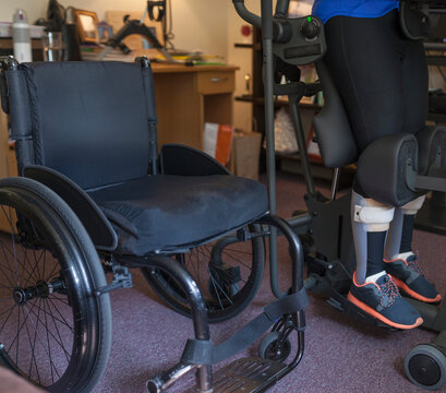 Woman with spinal cord injury getting into her desk so she can stand up