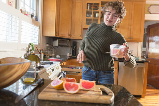 Woman with Sjogren-Larsson Syndrome putting grapefruit in a container
