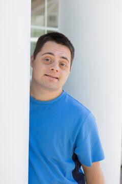 Man with Down Syndrome leaning against a wall
