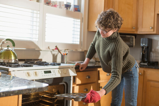 Woman with Sjogren-Larsson Syndrome putting a tray in oven