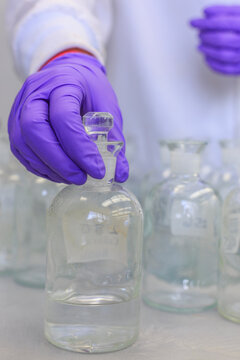 Lab chemist holding reagent bottle
