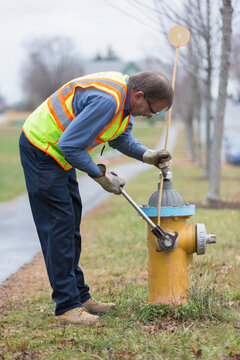 Water department technician installing a snow stake