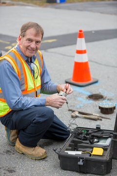 Water department technician using flow rate sensor