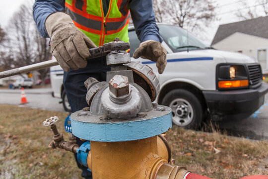 Water department technician shutting fire hydrant to flush water pipes