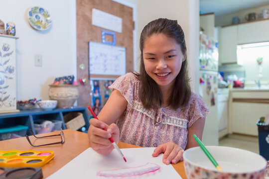 Teen girl with a Learning Disability using paints