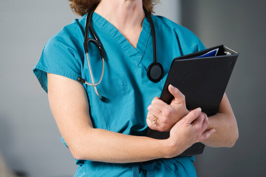 Midsection of a nurse with stethoscope and file