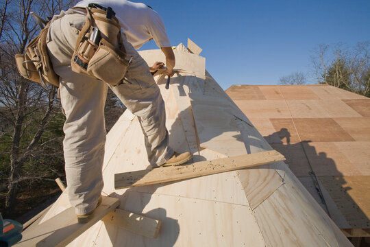 Carpenter working on the turret of a house
