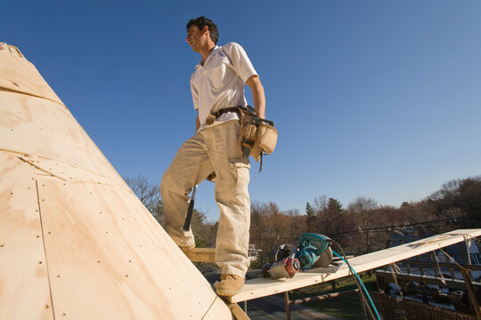 Carpenter working on the turret of a house
