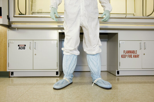 Scientist in protective wear standing in a clean room