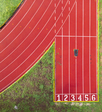 Aerial view of the red running track at Instituto Tecnologico de Merida with white lane markings and numbered starting blocks Merida, Yucatan, Mexico.