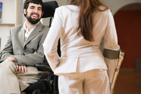 Man with Cerebral Palsy and woman with cane conversing