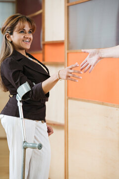 Businesswoman with cane shaking hands