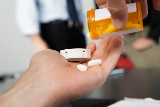 View of a businessman taking drugs in the office