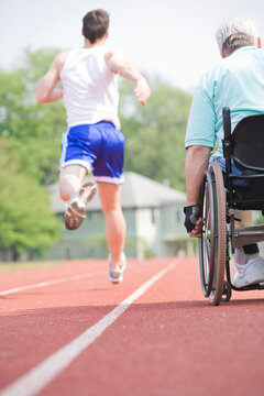 Rear view of runners racing on a racetrack
