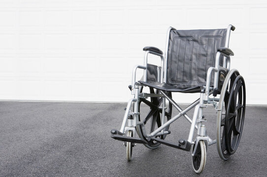 Empty wheelchair in front of a garage