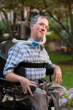 Man with Duchenne muscular dystrophy sitting in a wheelchair with a breathing ventilator