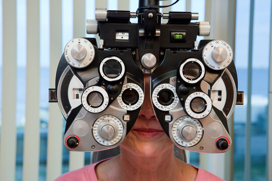 Woman getting eye exam with a phoropter