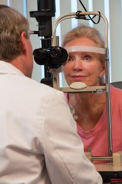 Ophthalmologist examining a woman's eyes with a slit lamp