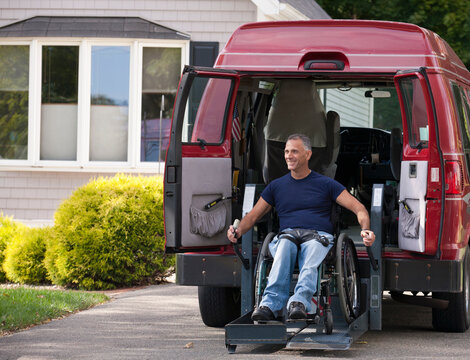 Man with spinal cord injury in a wheelchair getting in his accessible van