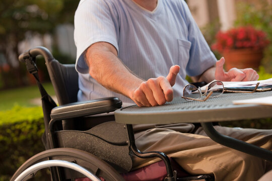 Businessman with Friedreich's Ataxia reaching for his glasses with hand degeneration