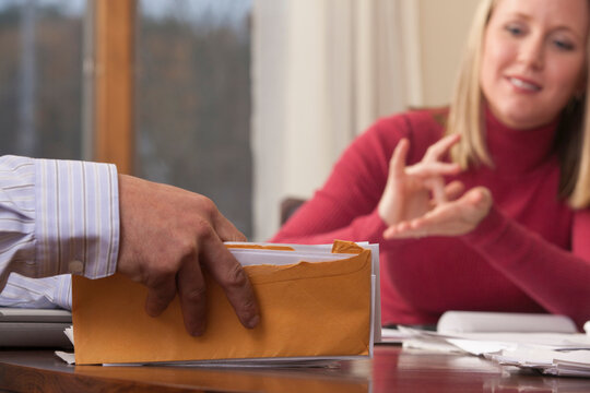 Woman signing the phrase 'Health insurance' in American Sign Language while communicating with a man