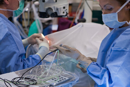 Surgical technologist passing a phaco hand piece to doctor during cataract surgery