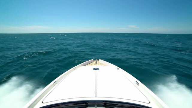 Luxury yacht bow cutting ocean waves blue water, white spray arcing from bow, open ocean horizon, cinematic yacht b-roll footage for luxury travel marine brand and lifestyle content.